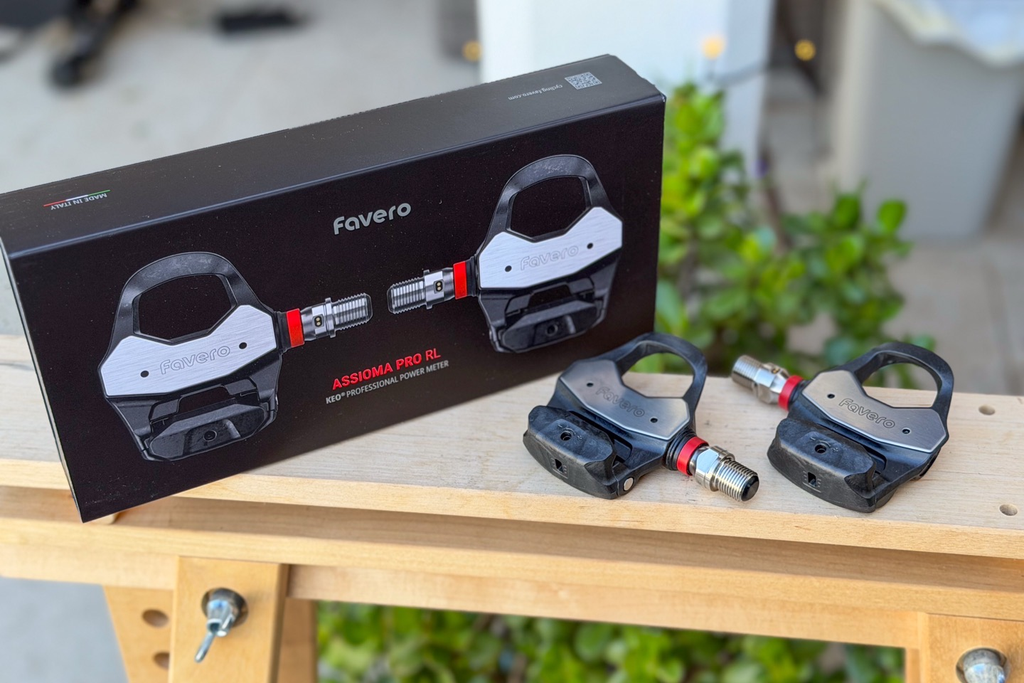 Favero Assioma Pro RL pedals with original packaging displayed in real-world outdoor setup