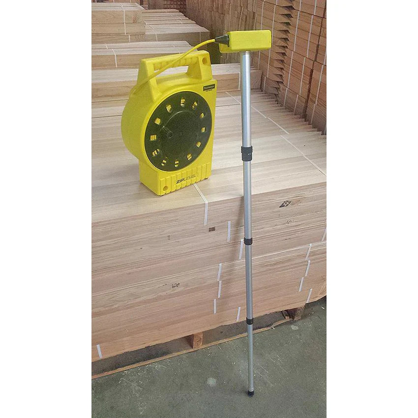 ZipLevel PRO-2030 handheld unit and base set up on an outdoor construction site with cord extended.