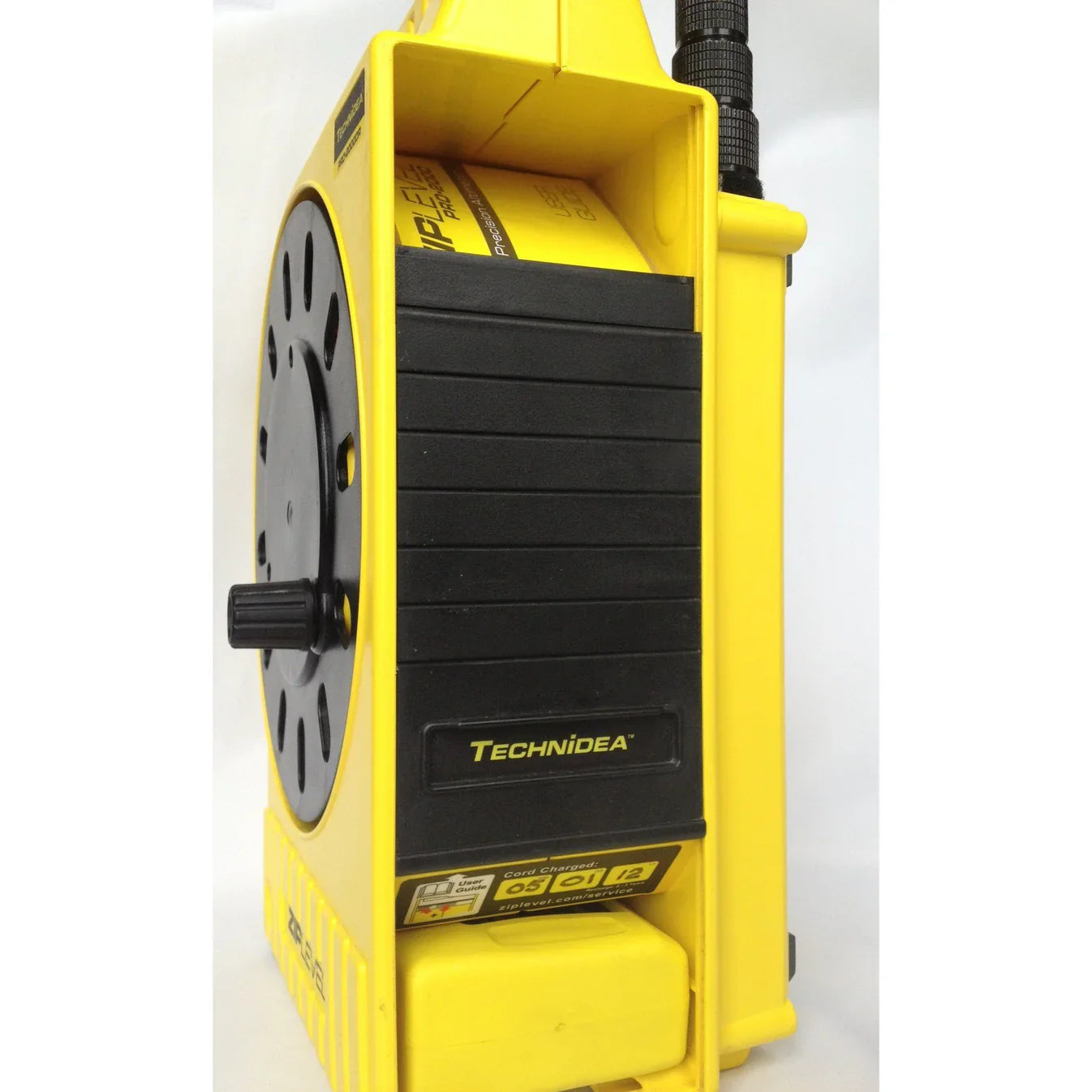 ZipLevel PRO-2030 handheld unit and base set up on an outdoor construction site with cord extended.