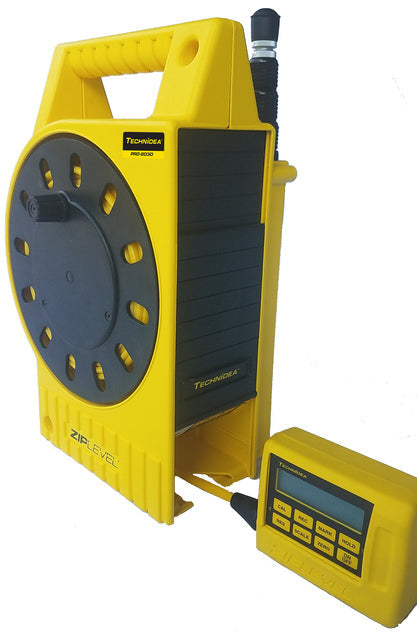 ZipLevel PRO-2030 handheld unit and base set up on an outdoor construction site with cord extended.